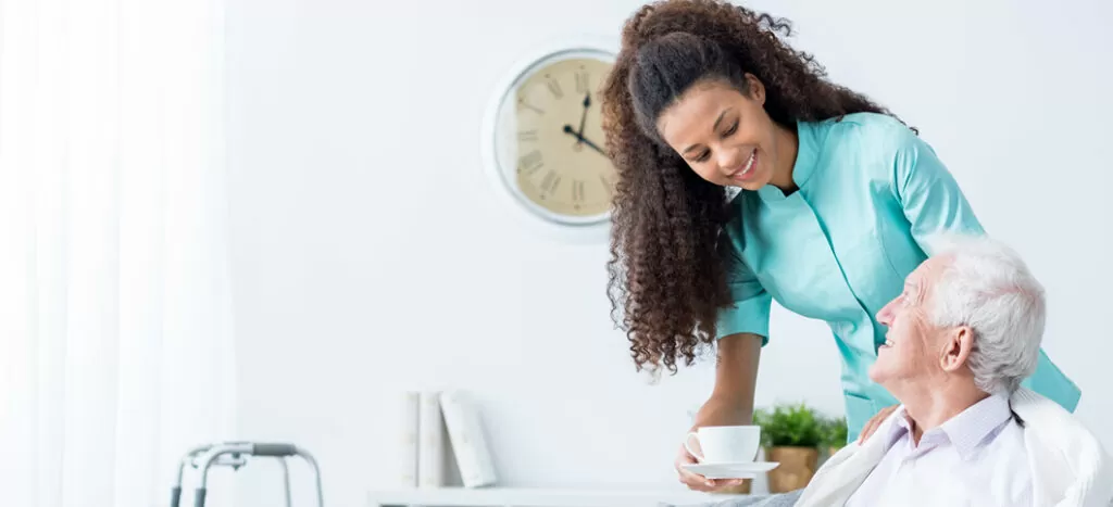 A woman holding a plant and smiling.