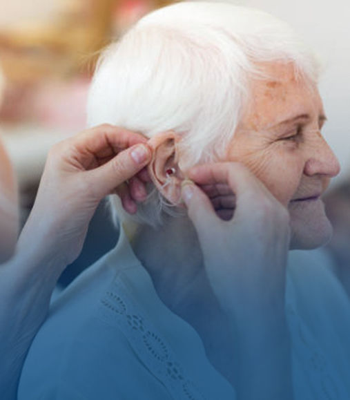 A woman fixing the hearing amplifier in the woman's ear