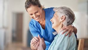 A caregiver smiling and holding the woman
