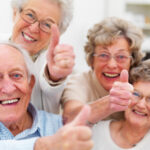 Four old people giving a thumbs up