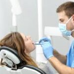 A dentist checking the client’s teeth