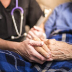 A Hospice Nurse visiting an Elderly male patient