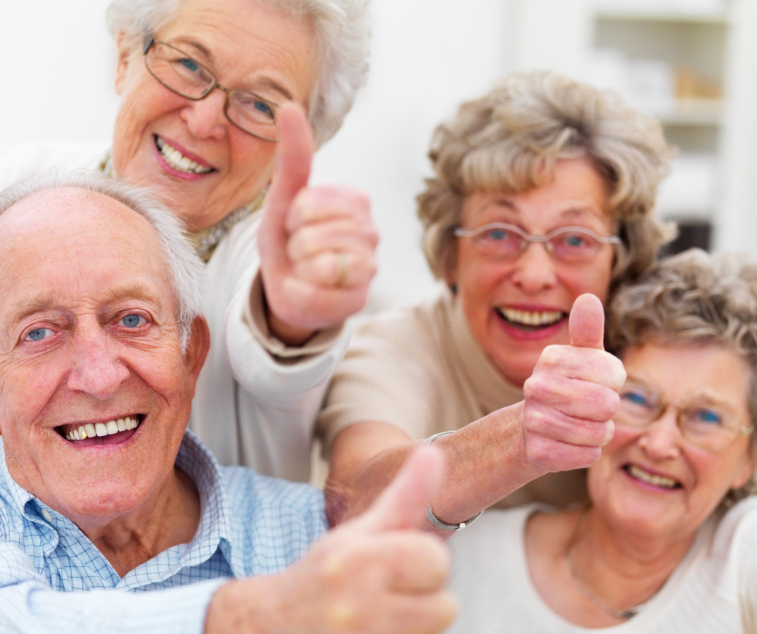Four old people giving a thumbs up