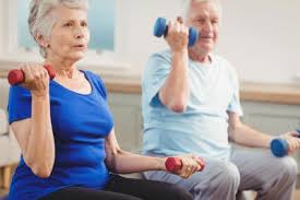 A senior couple sitting and doing a workout with dumbbells