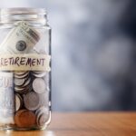 A glass jar with retirement sticker filled with money