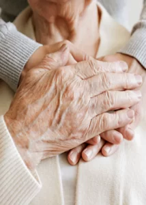 A close up of an old person holding someone 's hands