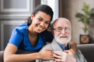 A nurse holding the old man's shoulder and posing