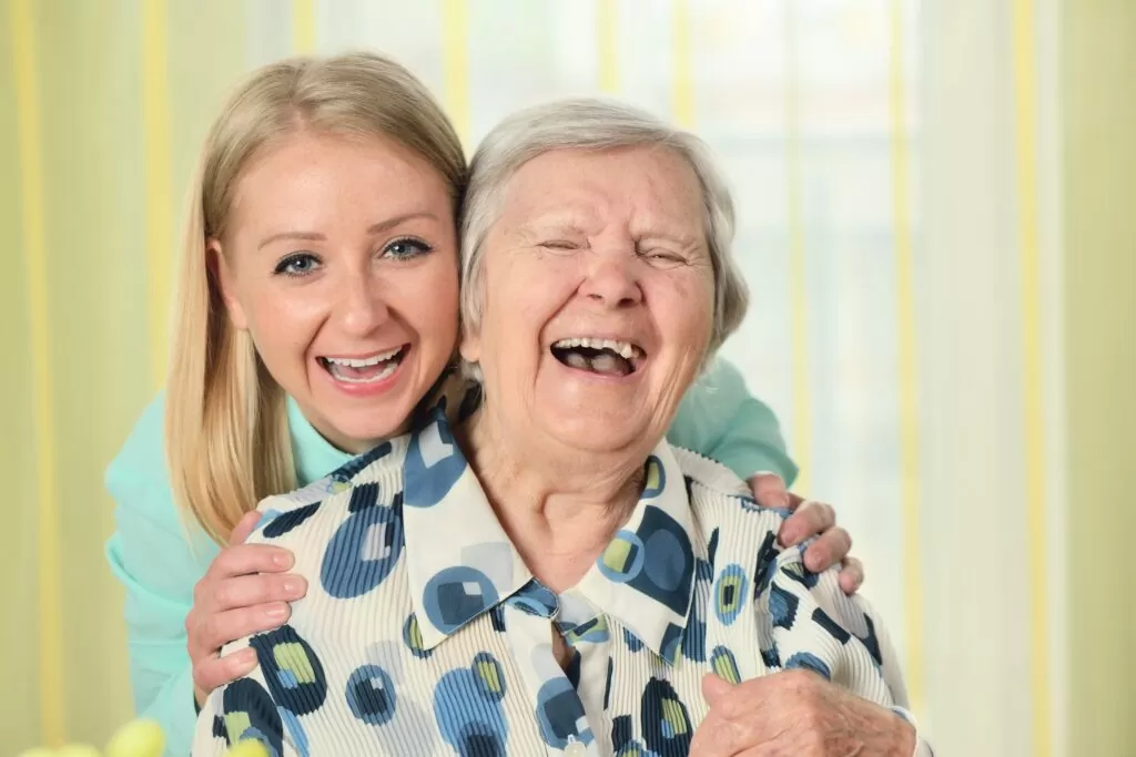 A woman and an old lady smiling for the camera.