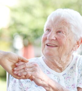 Elderly lady holding caregivers hand - In home dementia care Pebble Beach