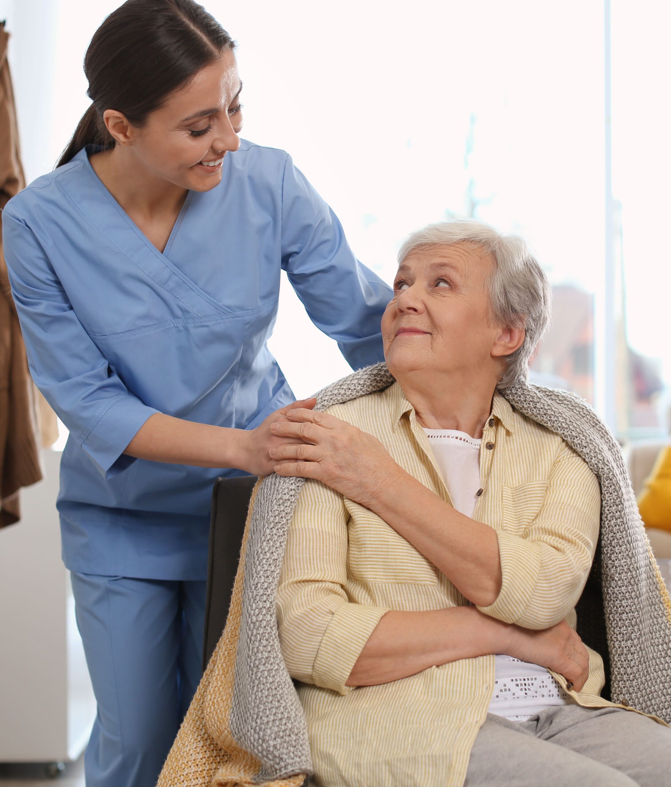 55+ lady smiling touching caregivers hand - Monterey Home Personal Care