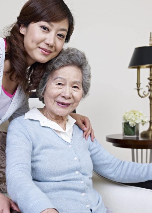 elderly asian woman sitting with caregiver - Pacific Grove in Home Personal Care